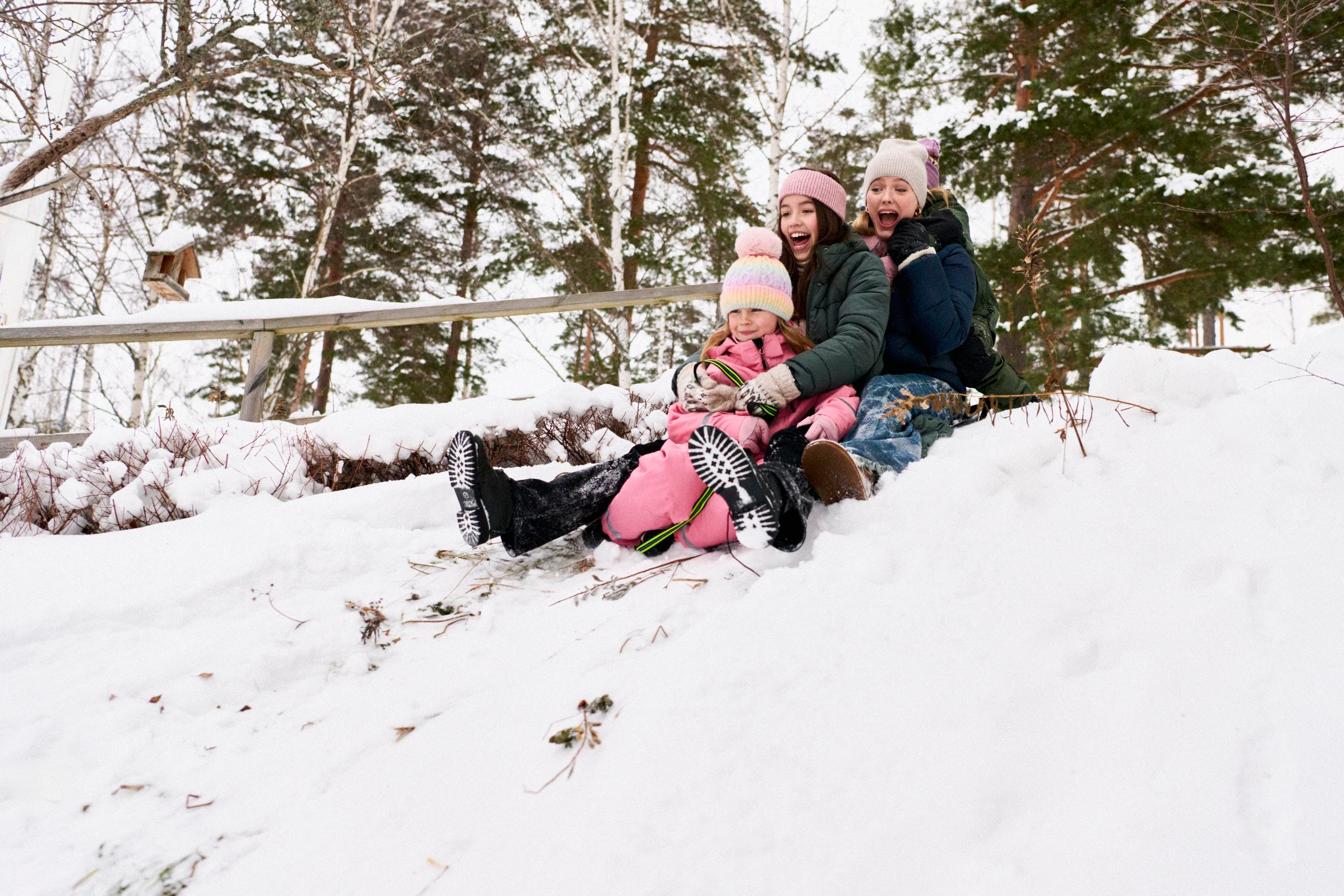 Barn och tonåringar åker kälke tillsammans